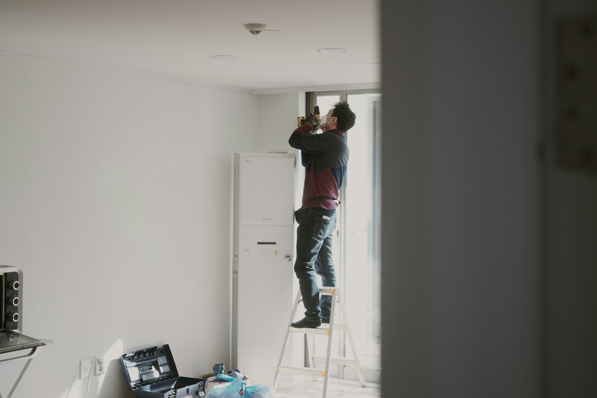 Professionnel intervenant en hauteur dans un intérieur, image d’illustration